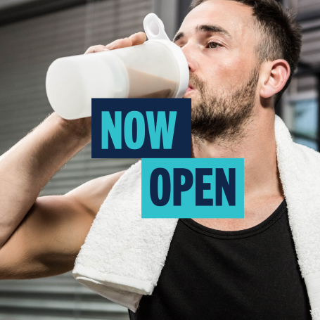 Man drinking supplement shake with text saying Now Open